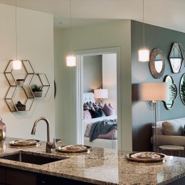 a kitchen island and a living room with green walls