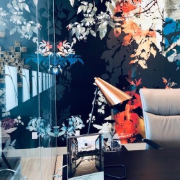 a room with a colorful wallpaper and a desk with a chair